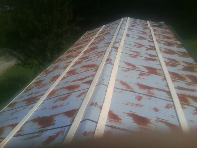 Rusted metal roof panels with new wood purlins before replacement — Storm Damage Roof Repair in Port Washington by Roofing Brothers