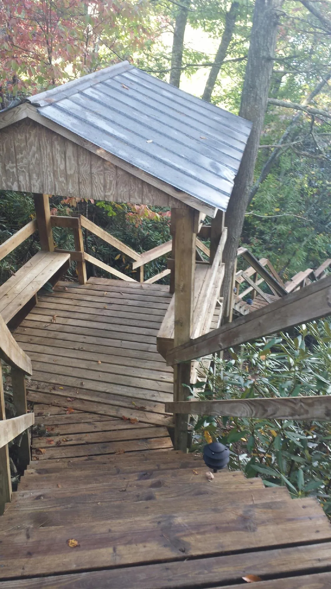 Metal roofed shelter over wooden steps on a wooded walkway — Skylight Repair & Installation work by our crew in Port Washington